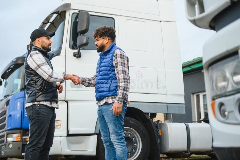Two logistics partners shaking hands in front of a fleet of trucks